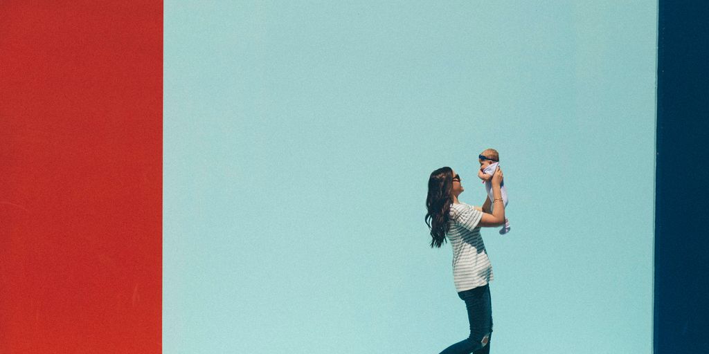 woman carrying baby while walking
