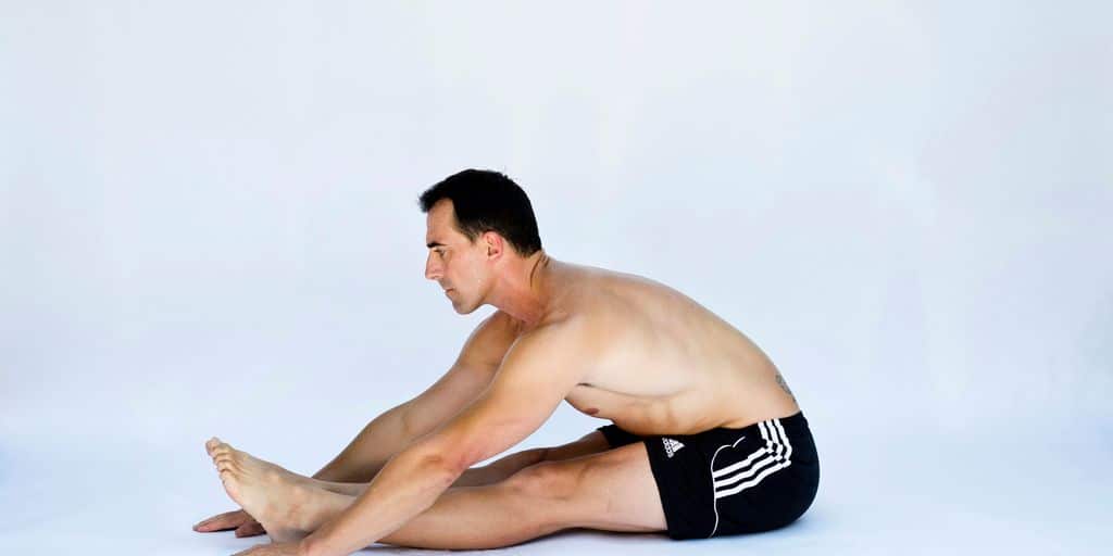 a shirtless man is sitting on the floor