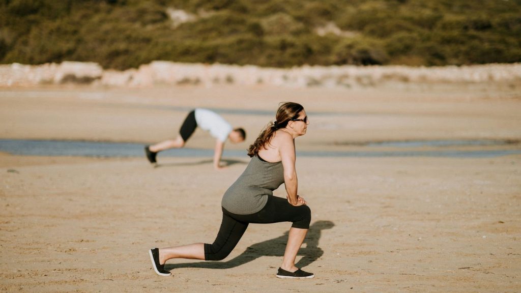 woman wearing grey tank top doing exercise