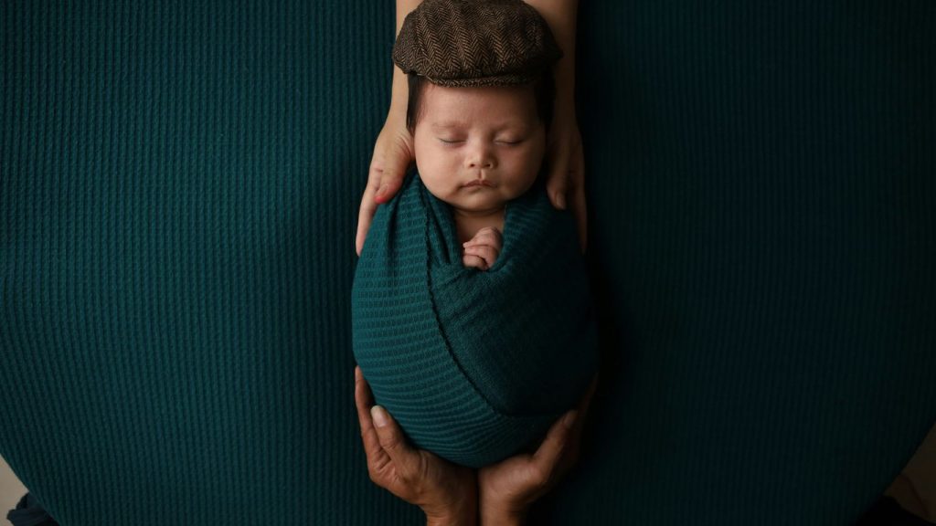 a woman holding a baby wrapped in a blanket