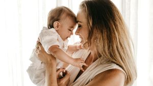 smiling woman carrying baby