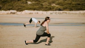 woman wearing grey tank top doing exercise